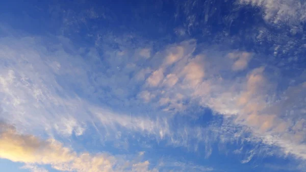 white clouds on a blue background at sunset
