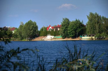  Göl masmavi bir deniz, ağaçlar ve kıyısında güzel bir ev