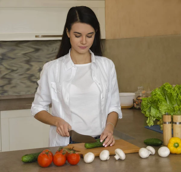 Flicka i köket förbereder en sallad — Stockfoto