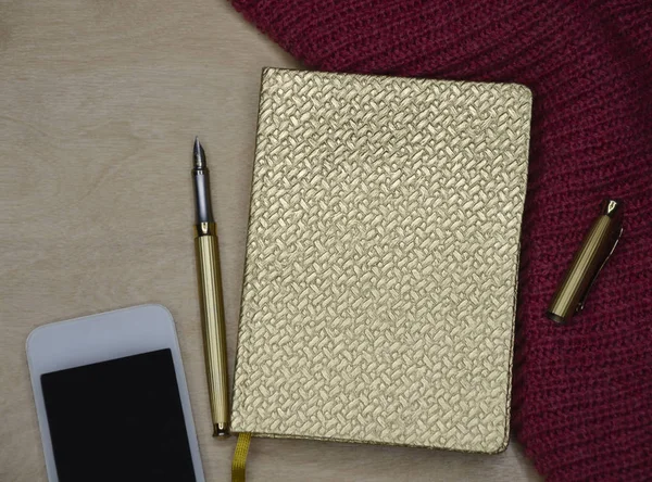 Bloco de notas dourado com caneta e telefone — Fotografia de Stock