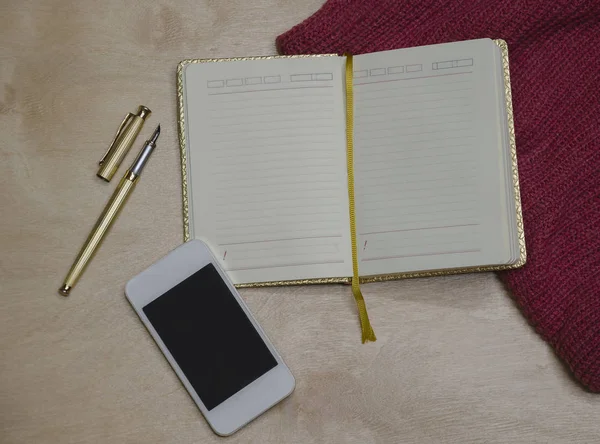 Золотий блокнот з ручкою і телефоном — стокове фото