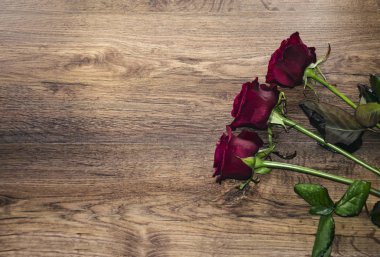 Ahşap arka planda kırmızı güller