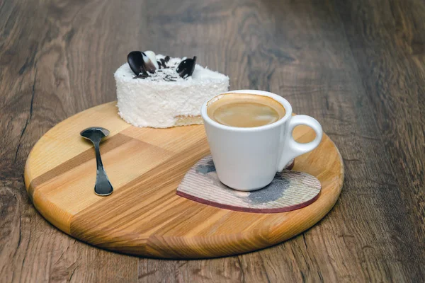 Taza de café y bizcocho blanco en un plato de madera —  Fotos de Stock