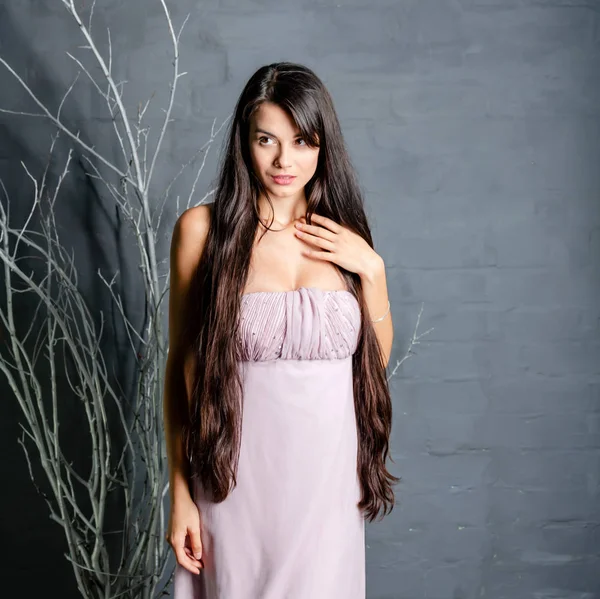 girl with long dark hair on a gray background,