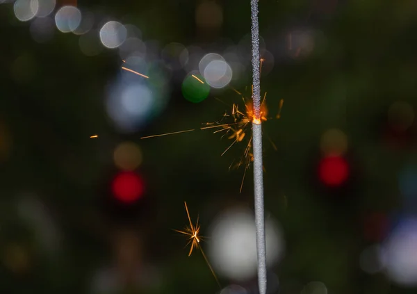 Bengáli fények repülő szikrákkal a háttérben egy karácsonyfa — Stock Fotó