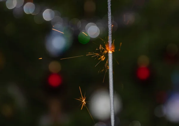 Luzes de bengala com faíscas voadoras no fundo de uma árvore de Natal — Fotografia de Stock