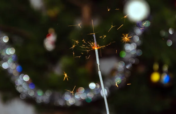 Luzes de bengala com faíscas voadoras no fundo de uma árvore de Natal — Fotografia de Stock
