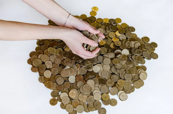 female hands take metal coins, face value of one hryvnia