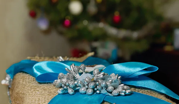 Gift wrapping with silver beads and blue bow with satin ribbon — Stock Photo, Image