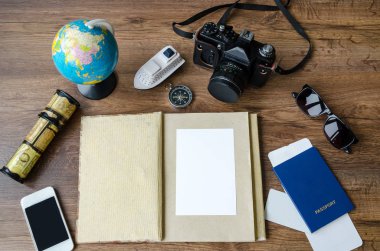 Not defteri, kredi kartları, pasaport, Bilet, fotoğraf makinesi, telefon ve pusula ahşap arka plan üzerinde