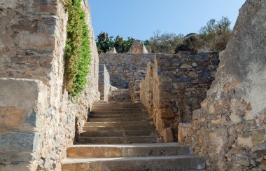 Spinalonga adasındaki eski binaların arasından çıkan merdivenler.