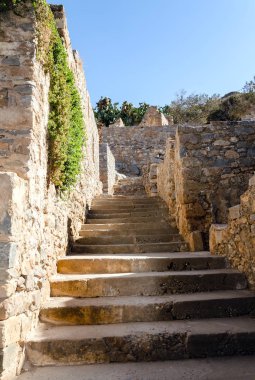 Spinalonga adasındaki eski binaların arasından çıkan merdivenler.