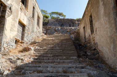 Spinalonga adasındaki eski binaların arasından çıkan merdivenler.