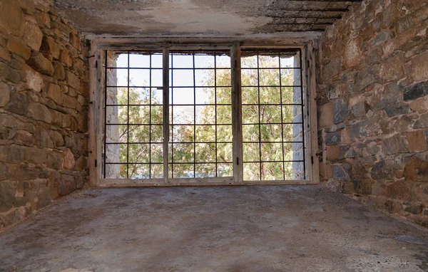 Utsikt från en gammal byggnad genom ett fönster med metallstänger — Stockfoto