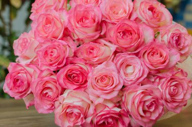 Tahta arka planda narin kokulu gül çiçekleri olan buket, bayram hediyesi.