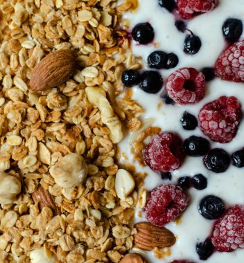 granola with yogurt and frozen raspberries and blueberries
