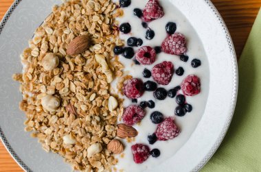 Sağlıklı kahvaltı, yoğurtlu granola, donmuş ahududu ve yaban mersini.