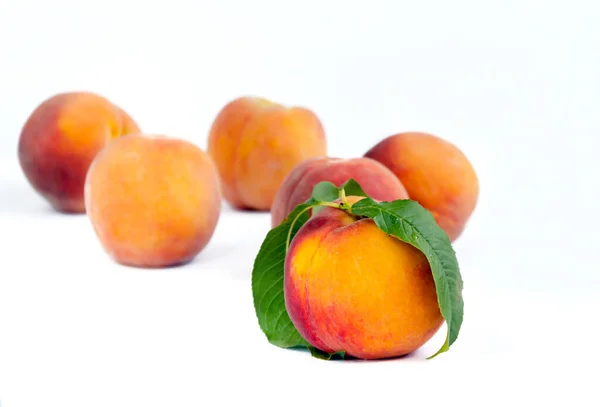 Peaches fruits with red sides in a slide on a light background — Stock Photo, Image