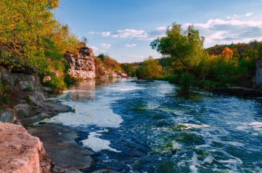Gorny Tikiç nehri, Ukrayna 'nın Buki kasabasında, güneşli bir sonbahar öğleden sonrasında, kayalar ve kanyon arasında akar.