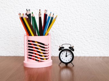 Alarm saati ve renkli kalemleri olan tablo, yaratıcılık için nesneler yakın plan