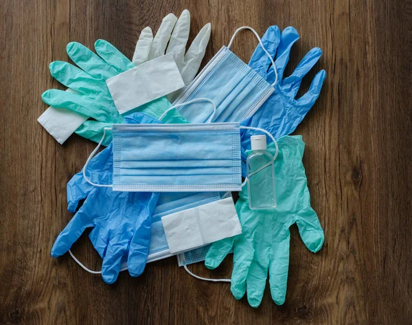 protective equipment against COVID-19, medical masks, rubber gloves, disinfector, on a wooden background, close-up