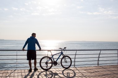 deniz manzara adam gündoğumu izlerken bisiklet ile
