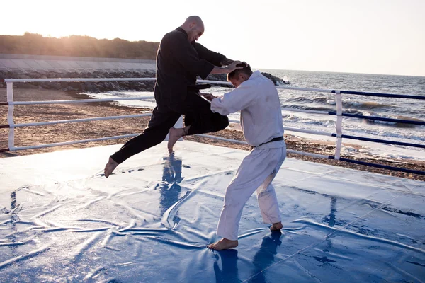 Karate fighters outdoor om the morning beach — Stock Photo, Image