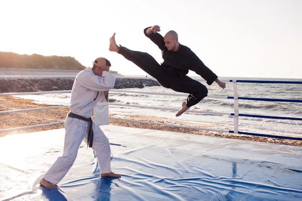 Dövüş sanatları açık havada uygulamak sabah ışığında iki karate savaşçıların görüntü Stok Fotoğraf