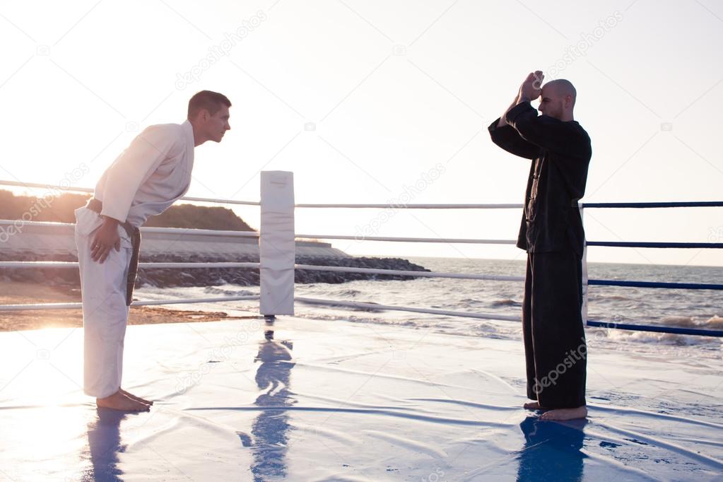 two professional karate fighters in sunrise light