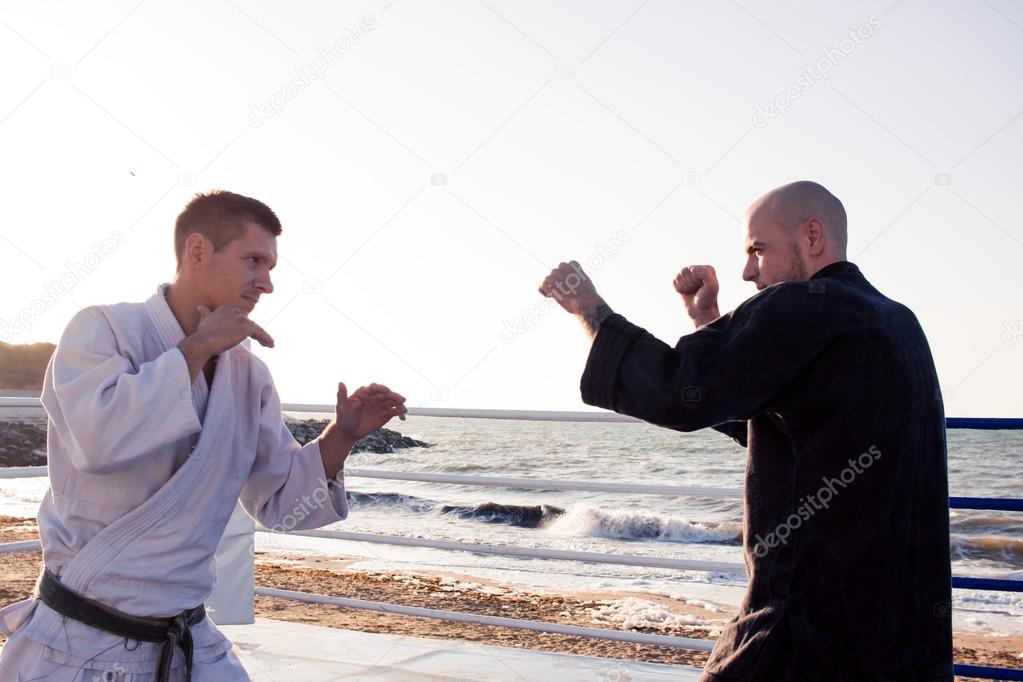 two karate fighters in morning light practicing martial arts 