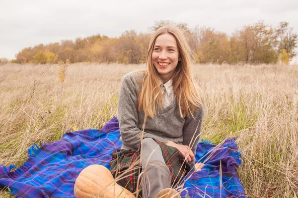 Uśmiechnięta młoda kobieta o czas na piknik z jabłkiem w dłoni — Zdjęcie stockowe