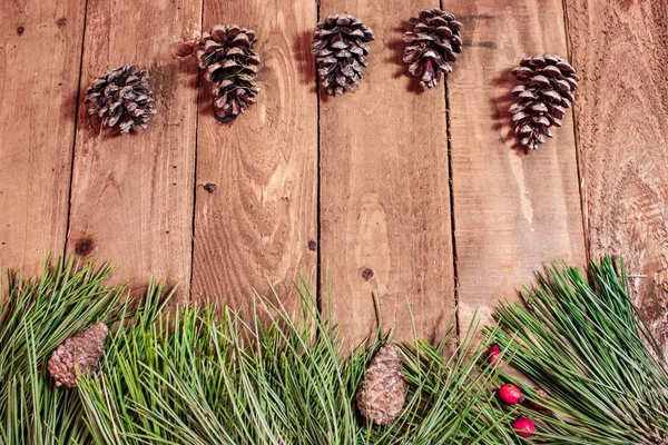 Latar belakang Natal pada meja kayu tua Berry merah dan cemara — Stok Foto