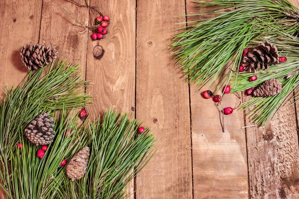 Fondo sobre la vieja mesa de madera rojo berrys y abeto — Foto de Stock