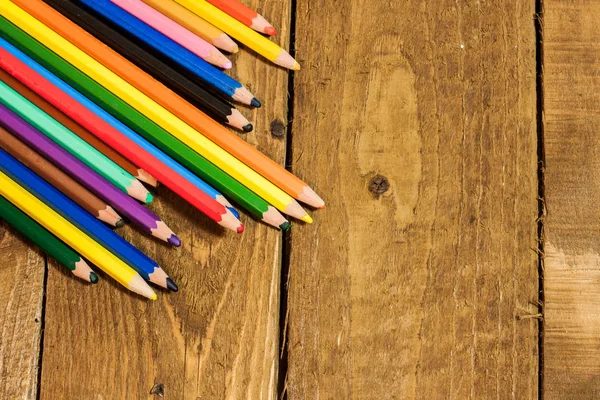 Cerrar imagen de papel en blanco y lápices de colores en la vieja mesa de madera — Foto de stock gratis