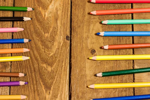 Fondo de lápices de colores en la vieja mesa de madera — Foto de stock gratis