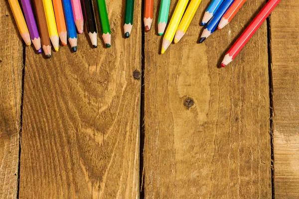Veel kleurrijke potloden op oude houten tafel — Stockfoto