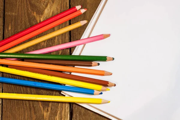 Picture of blank paper and colorful pencils on old wooden table — Stock Photo, Image