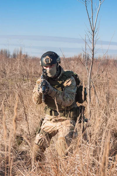 Soldado airsoft wolking en los campos de otoño con rifle de combate en las manos — Foto de Stock