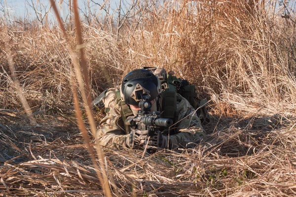 Soldado airsoft rastejando com uma espingarda em campos de outono — Fotografia de Stock