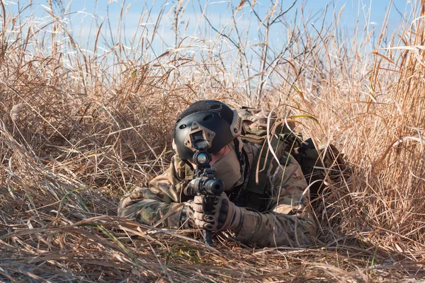 Soldat airsoft rampant avec un fusil dans les champs — Photo