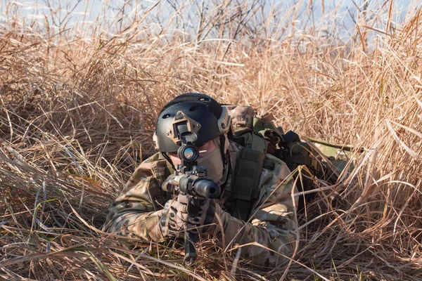 Airsoft soldier with a rifle lay down in bush — Stock Photo, Image
