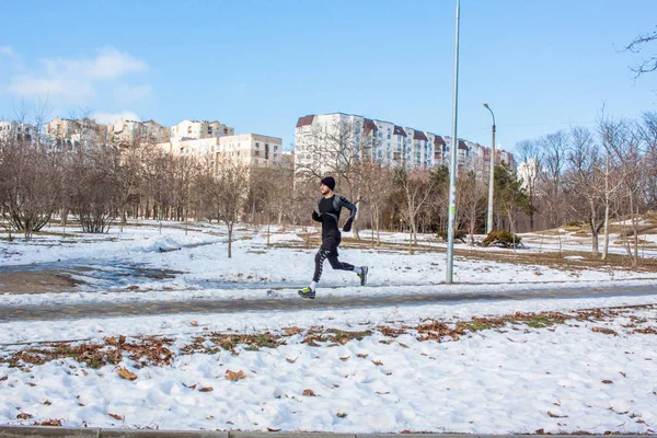 Człowiek w Odzież sportowa uruchomić w winter park — Zdjęcie stockowe