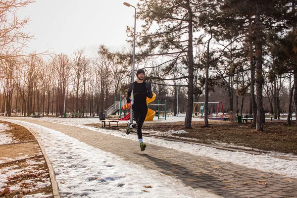 Człowiek w Odzież sportowa uruchomić w winter park — Zdjęcie stockowe