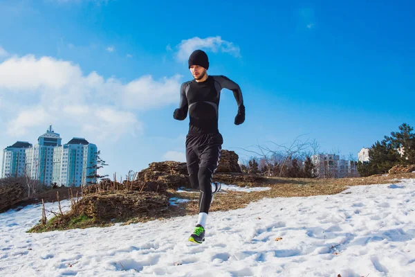 Młody człowiek runiczny na śniegu w Odzież sportowa — Zdjęcie stockowe