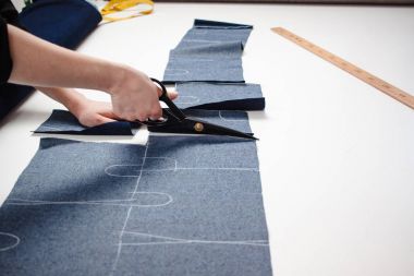 El kot kumaş beyaz masada makasla kesme terzi