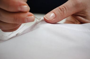 Beyaz kumaş ile iş yerinde bir terzi el yakın çekim resim