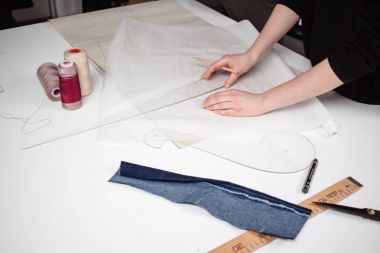 Terzi desen ve teyp ölçme çalışma tablosu üzerinde eller.