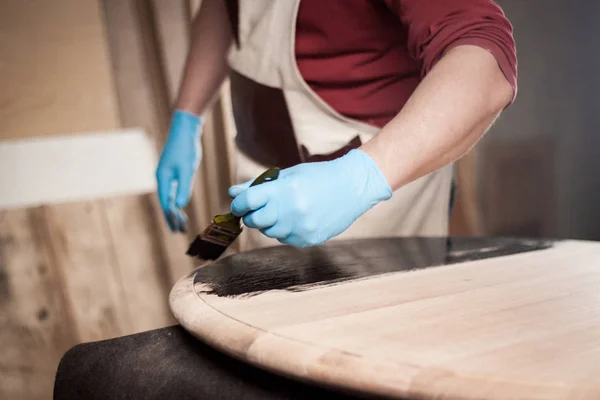 Close-up foto van hand met borstel schilderen houten tafel — Stockfoto