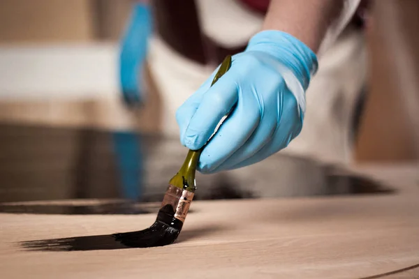 Close-up foto van hand met borstel schilderen houten tafel — Stockfoto