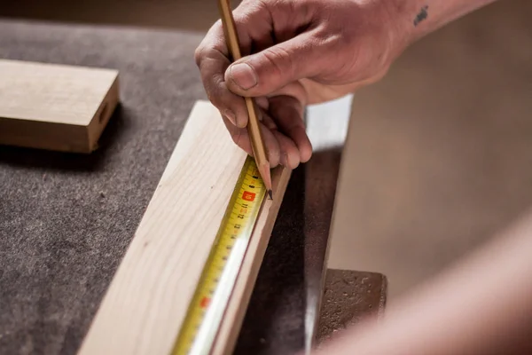 Homem pintando uma linha para cortar madeira — Fotografia de Stock